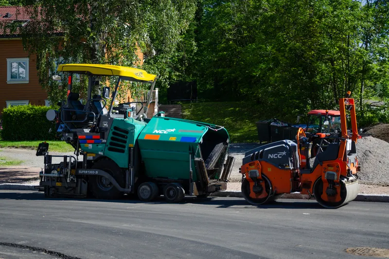 Silniční finišer Vögele pokládá asfalt, za ním válec