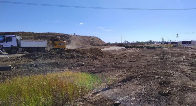 Pásové rýpadlo a nákladní auto na staveništi